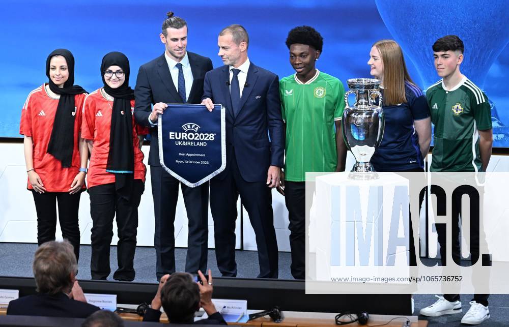 Ireland and United Kingdom confirmed to co-host 2028 UEFA European Football Championship GENEVA, SWITZERLAND - OCTOBER 10: UEFA President Aleksander Ceferin (C) and Welsh retired professional footballer, heading the delegation of UK and Ireland Gareth Bale (3rd L) hold the pennant as they pose with the pennant next to the trophy after United Kingdom and Ireland were elected to host the Euro 2028 football tournament during a ceremony held after the Executive Board meeting at the UEFA headquarters in Nyon, Geneva, Switzerland on October 10, 2023. Geneve Isviçre. Editorial use only. Please get in touch for any other usage.