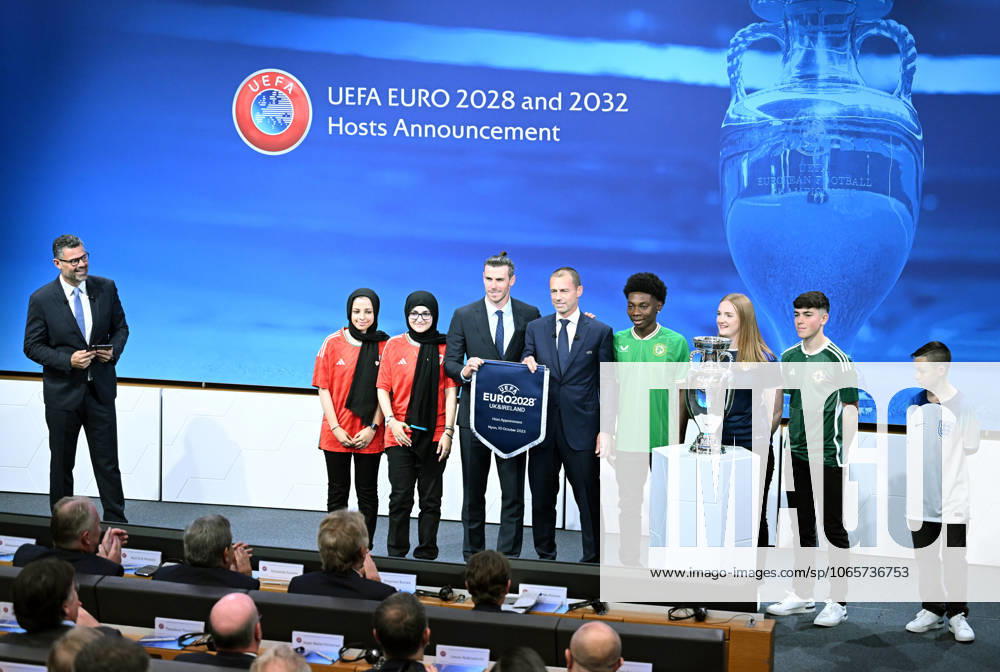 Ireland and United Kingdom confirmed to co-host 2028 UEFA European Football Championship GENEVA, SWITZERLAND - OCTOBER 10: UEFA President Aleksander Ceferin (4th L) and Welsh retired professional footballer, heading the delegation of UK and Ireland Gareth Bale (3rd L) hold the pennant as they pose with the pennant next to the trophy after United Kingdom and Ireland were elected to host the Euro 2028 football tournament during a ceremony held after the Executive Board meeting at the UEFA headquarters in Nyon, Geneva, Switzerland on October 10, 2023. Geneve Isviçre. Editorial use only. Please get in touch for any other usage.