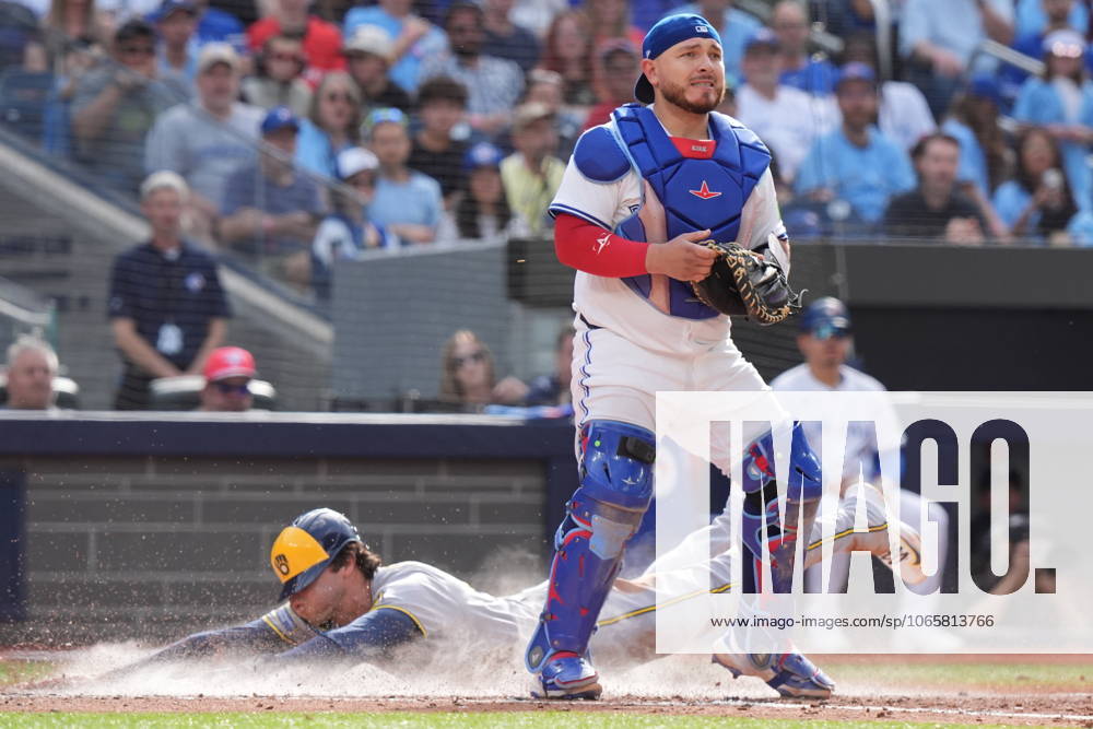 Toronto Blue Jays catcher Alejandro Kirk (30) looks for the ball as Milwaukee Brewers outfielder Christian Yelich (22) scores behind him during seventh inning MLB, Baseball Herren, USA baseball action in Toronto on Saturday, August 30, 2025. Canada News - August 30, 2025 - ZUMAc35_ 20250830_zaf_c35_039