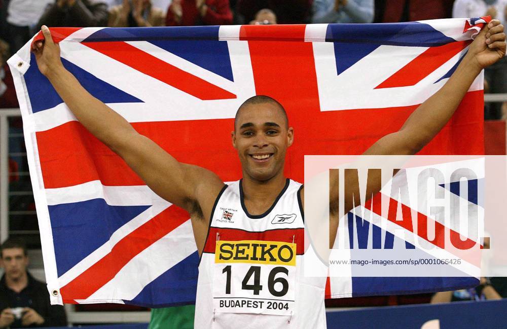 Weltmeister Jason Gardener (Großbritannien) jubelt mit dem Union Jack Leichtathletik WM Herren 10. IAAF Hallen-Weltmeisterschaft 2004, Hallenweltmeisterschaft, Halle, Indoor, Nationaltrikot Einzelbild Budapest Freude,