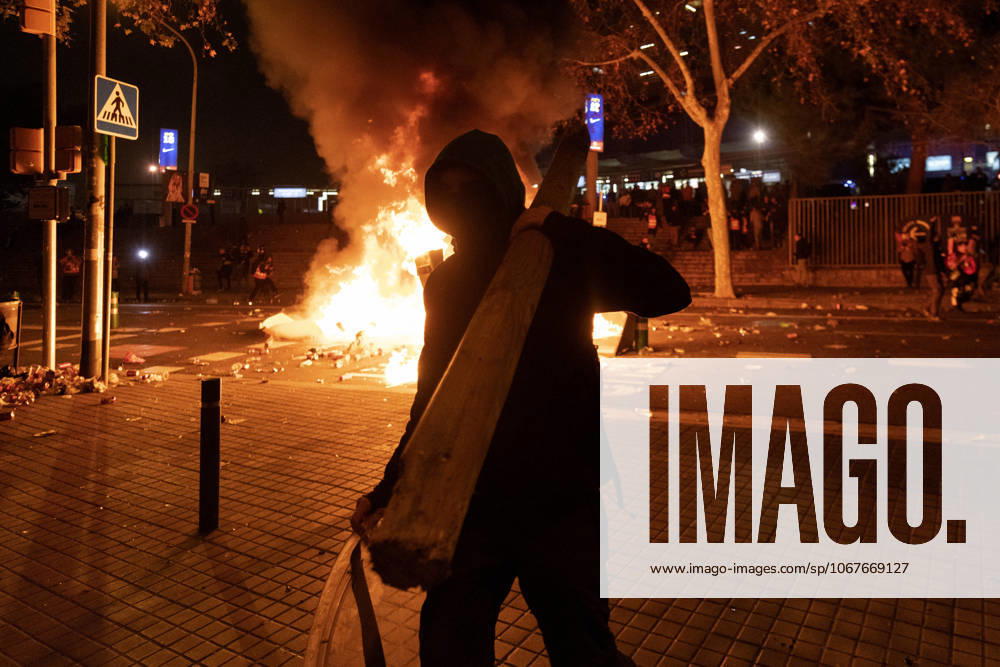 FC Barcelona, Barca v Real Madrid: La Liga BARCELONA, SPAIN - DECEMBER 18: A protester carries a wood near a burning barricade during a protest called by Catalan separatist movement Democratic Tsunami outside the Camp Nou stadium in Barcelona on December 18, 2019, during the El Clasico Spanish League football match between Barcelona FC and Real Madrid CF. Catalonia Spain. Editorial use only. Please get in touch for any other usage.