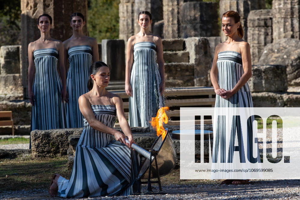 (251126) -- ANCIENT OLYMPIA, Nov. 26, 2025 -- Actress Mary Mina (front), in the role of an ancient Greek High Priestess, lights the flame during the dress rehearsal of the Olympic flame lighting ceremony for the Milan-Cortina 2026 Winter Olympic Games, Olympische Spiele, Olympia, OS in Ancient Olympia, Greece, on Nov. 24, 2025. (Photo by Xinhua) (SP)GREECE-ANCIENT OLYMPIA-MILAN-CORTINA 2026-FLAME LIGHTING CEREMONY MariosxLolos
