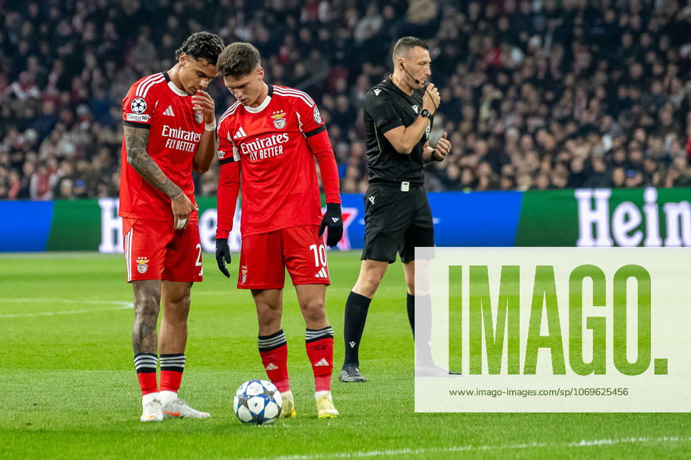 Football UEFA Champions League, Season 2025 2026, Group stage, Matchday 05, Ajax Amsterdam Benfica Lisbon at the Johan Cruijff ArenA in Amsterdam Richard Rios Benfica Lisbon, 20 and Georgiy Sudakov Benfica Lisbon, 10 in conversation before taking the free kick Next to referee Sven Jablonski Photo Kirchner Media Thomas Haesler