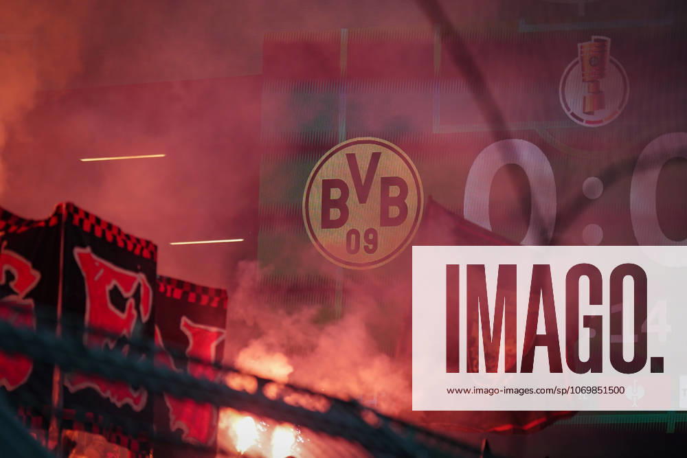 Germany Football DFB Cup 2025 26, Round of 16 Borussia Dortmund vs Bayer 04 Leverkusen Signal Iduna Park Dortmund Pyro in the curve, red glowing smoke in front of BVB logo and DFB Cup scoreboard, fan curve dynamics, Ultras, fan culture, derby heat, emotions, safety debate, stadium safety, fan protests, Bundesliga, national cup round, identity, tradition, atmosphere, stadium politics, media focus, major event, spectator atmosphere