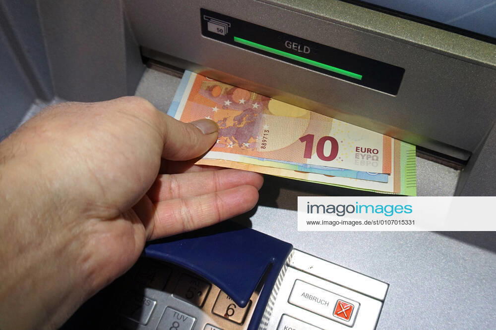 Cash supply from a cash dispenser A person fetches cash from a cash dispenser