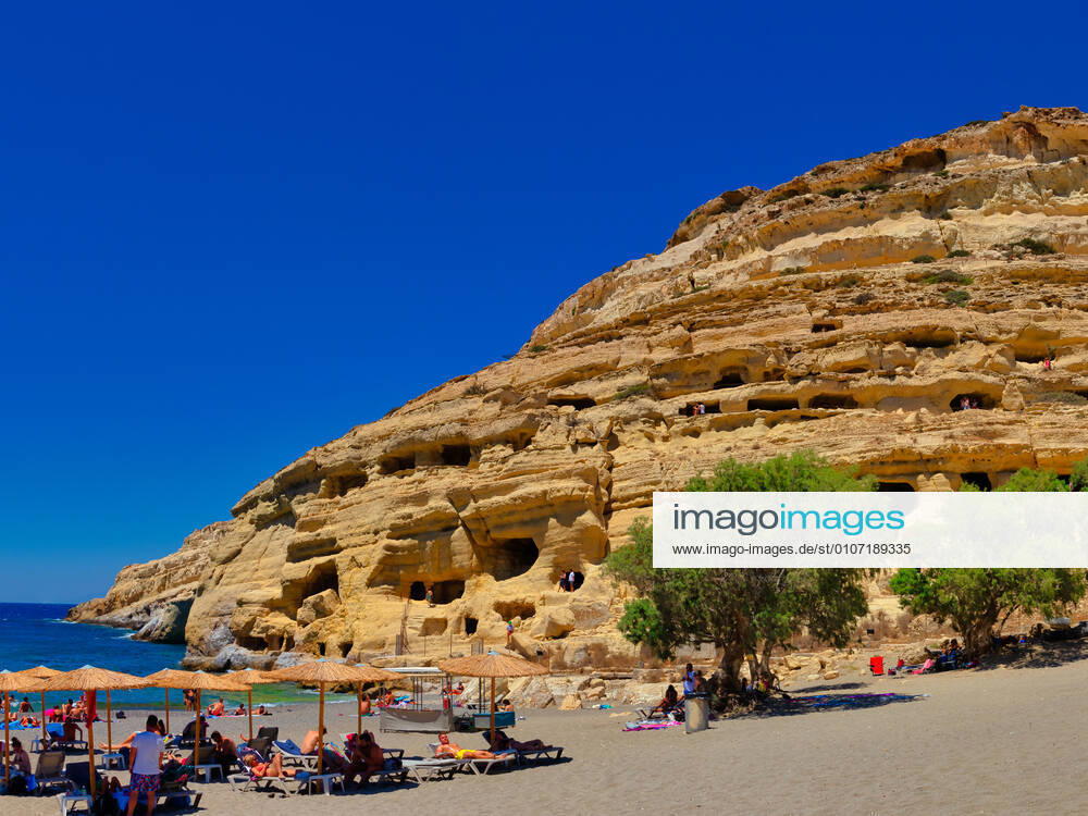 Holidaymakers relax on the beach of Matala on the Greek island of Crete 1096200466