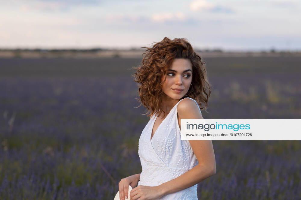 Woman with curly hair wearing a hat in a lavender field Madrid, Community of Madrid, Spain CR_JOCE201128-567996-01 ,model released, Symbolfoto