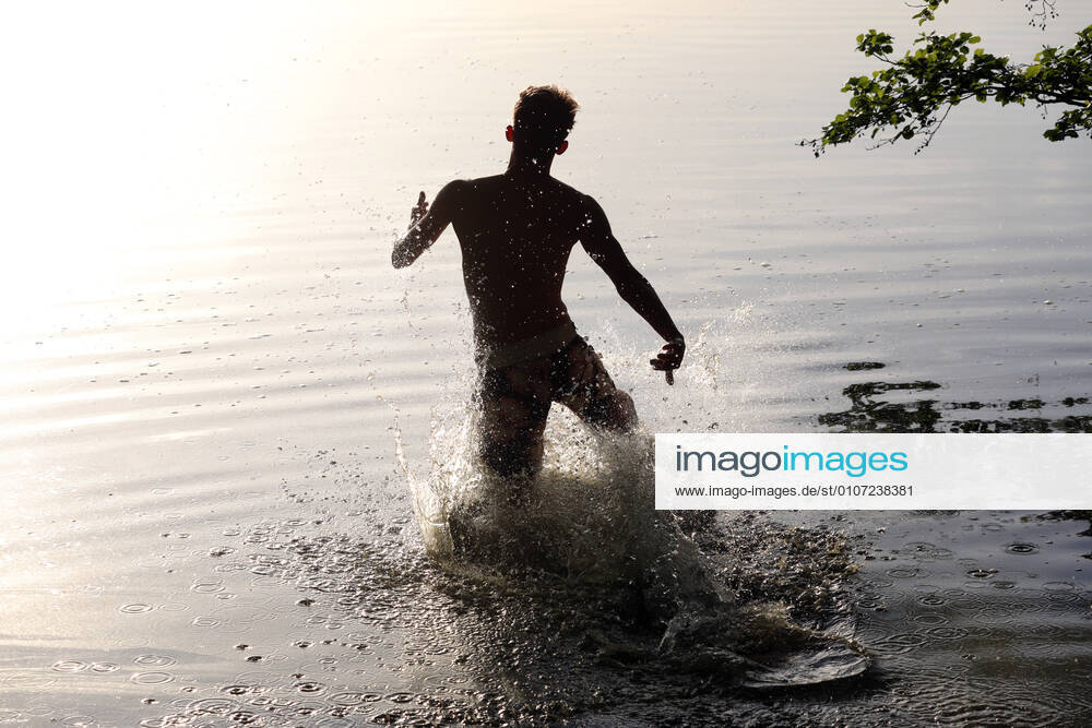Dranse, Brandenburg, GER silhouette youth running into a lake MR yes, 15 20 years, evening, evening light, evening, alone, outside, outdoor, outdoor
