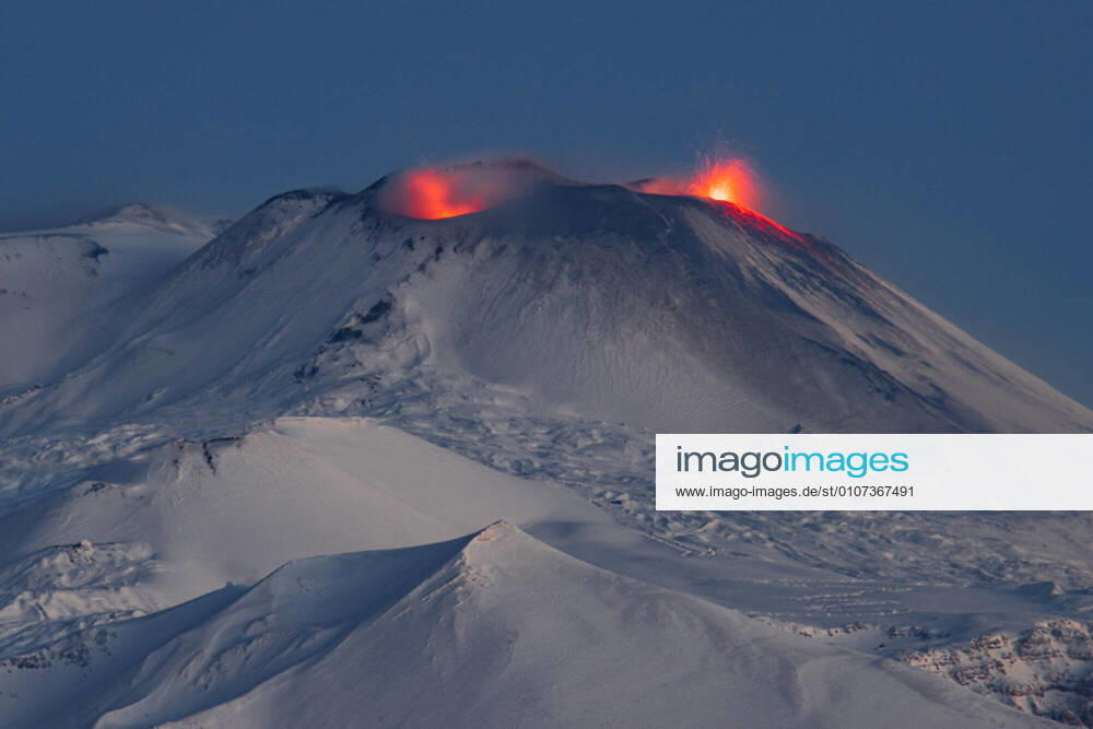 Italien, Vulkan Ätna auf Sizilien ausgebrochen Catania. Etna The eruptive activity of the three craters continues, the gleams that illuminate the snow are spectacular Editorial Usage Only