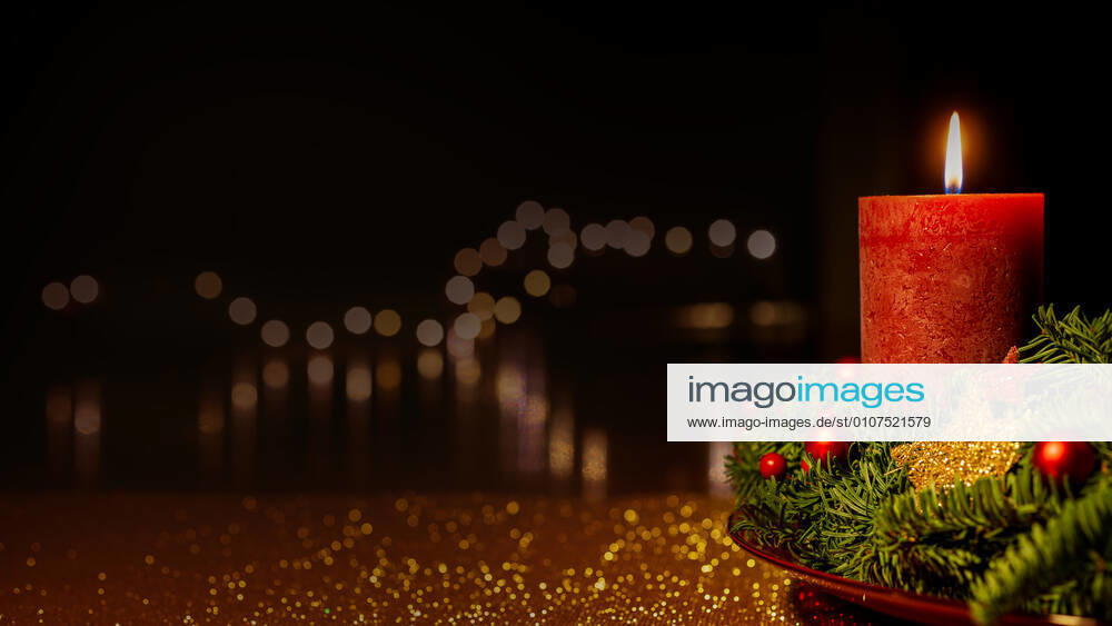 Advent wreath Burning red candle at an Advent wreath, decorated with red balls and golden stars in front of a dark bokeh background xRMS17XJ43x