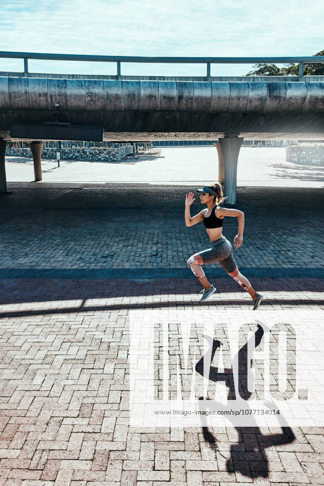 One mile at a time.. full length, Freisteller shot of an attractive and athletic young woman running through the city (License=RF) 20176633 ,model released, Symbolfoto
