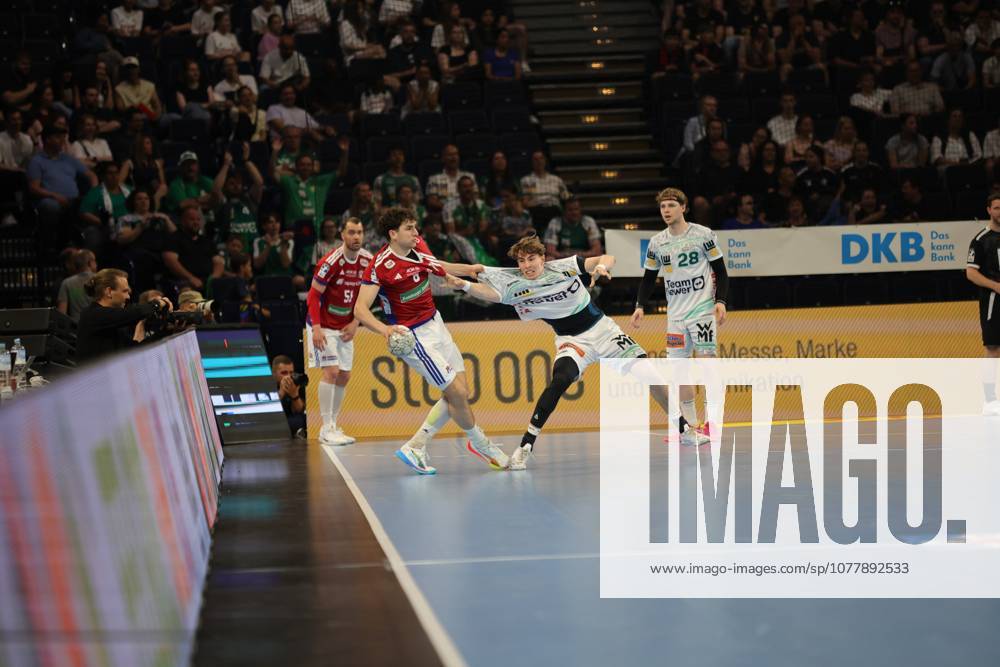 Torsten Jansen, head coach of HSV Hamburg, watches the action from the sidelines in the Barclays Arena A player in the red HSV jersey and defender from Frisch Auf Göppingen in the white jersey fight for the ball while the crowd watches the game Torsten Jansen watches the game scene at the DAIKIN HBL match