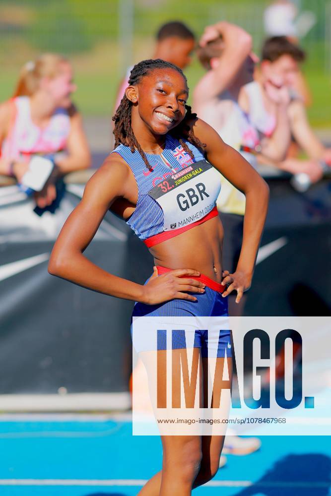 An athlete from Great Britain poses smiling on the tartan track of the Michael Hoffmann Stadium in Mannheim Her bib number reads GBR and the words 32 Junior Gala Mannheim 2024 Athlete from Great Britain at the 32 Junior Gala in Mannheim