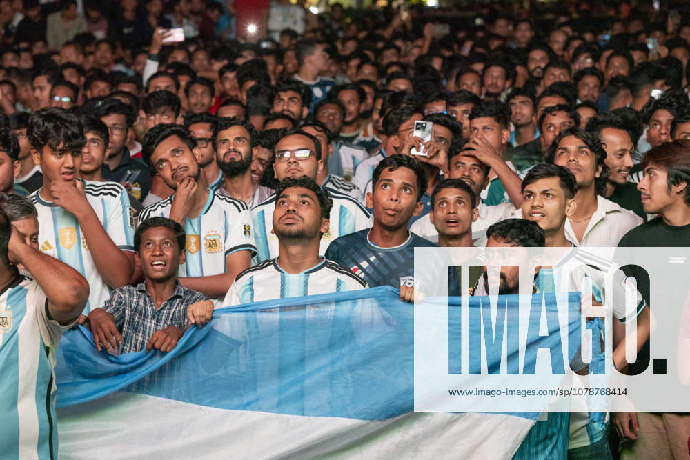 Bangladesh: Football Fans Gather To Watch Argentina Vs Austria World Cup Match In Chattogram A group of young football supporters look toward a big screen, holding an Argentina flag, with expressions of suspense and excitement during a match in Chattogram, Bangladesh, on June 23, 2026. Hundreds of Bangladeshi football fans gather at Kazir Dewri to watch the FIFA World Cup, WM, Weltmeisterschaft, Fussball match between Argentina and Austria on a giant screen. The event reflects Bangladesh s enthusiasm for international football, with many supporting teams like Argentina. Chittagong Bangladesh