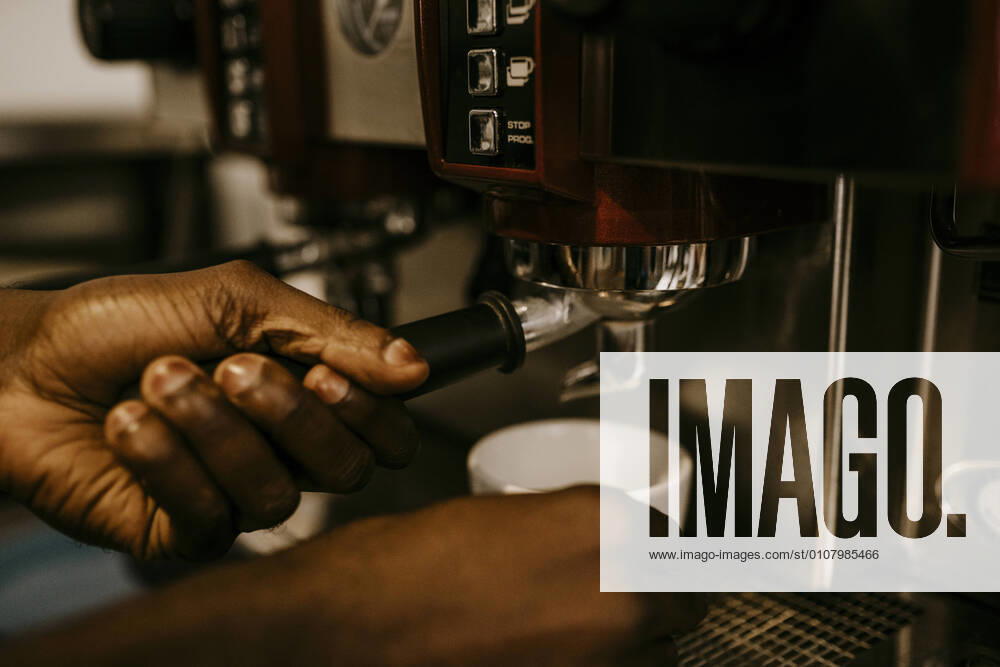 Cropped hand of male owner making coffee in cafe, MA82970, Germany, Berlin, model released, property released