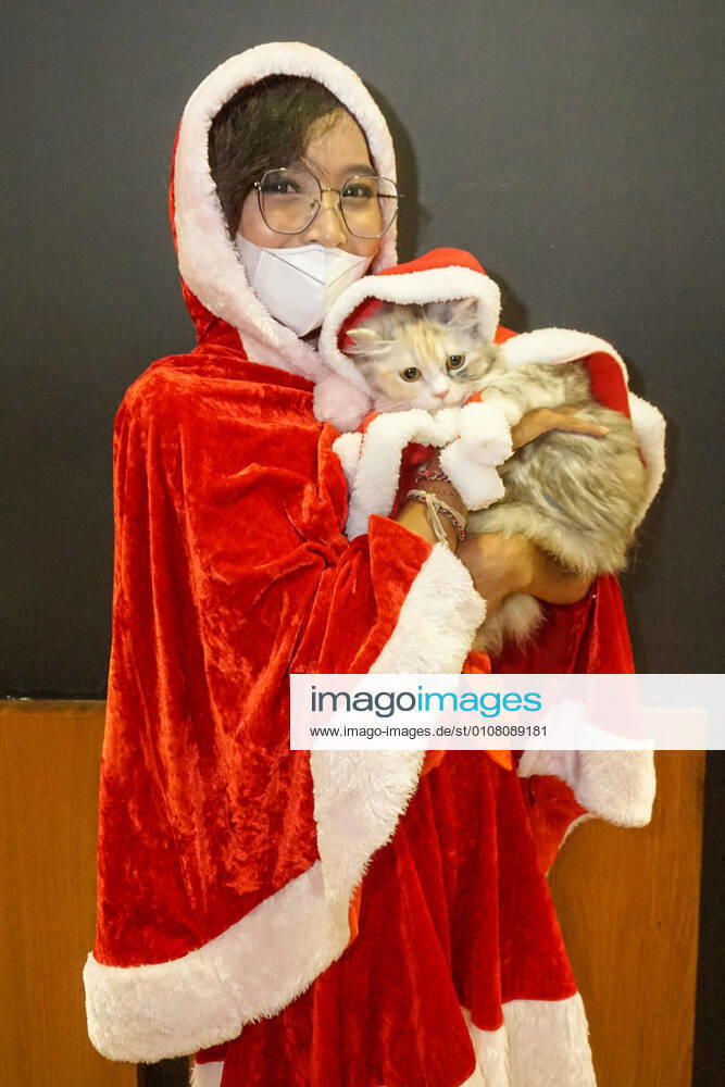 Bilder des Jahres 2020, Entertainment 12 Dezember Entertainment Themen der Woche KW50 December 12, 2020, Denpasar, Bali, Indonesia: A woman wearing Santa Claus costume carrying her cat with the same theme. A pet Christmas costume parade held in Level 21 Mall in order to celebrate 12.12 National Online-Shopping Day and the Christmas. Denpasar Indonesia - ZUMAb245 20201212_zip_b245_015