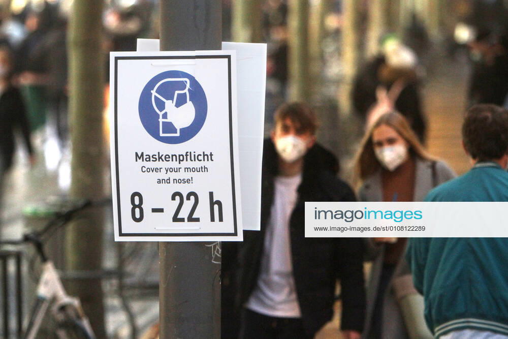 A sign with pictogram and inscription Maskenpflicht from 8 a.m. to 10 p.m. hangs in the shopping street and pedestrian zone Zeil in downtown Frankfurt, Hesse, Germany