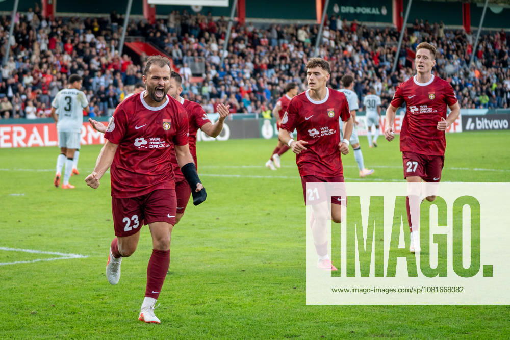 Fabian Eisele of SG Sonnenhof Großaspach, 23, celebrates after scoring a penalty kick to tie the game at 2–2 with Luca Molinari of SG Sonnenhof Großaspach, 21, Loris Maier (SG Sonnenhof Großaspach, 27), and Marius Kunde (SG Sonnenhof Großaspach, 16), SG Sonnenhof Großaspach vs. Arminia Bielefeld, soccer, DFB Cup, 1st round, August 22, 2026, DFB regulations prohibit any use of photographs as image sequences and or quasi-video. Aspach, Baden-Württemberg, Germany
