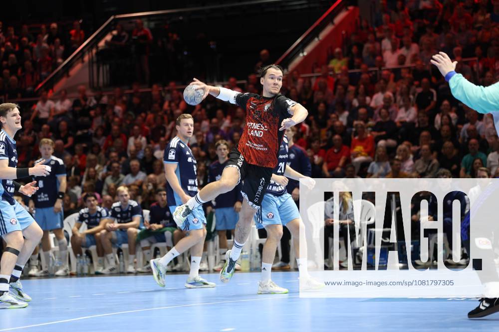 Dominik Axmann (15, HSV Hamburg) pulls away to take a jump shot, while Moritz Sauter (33, HSV Hamburg) watches the action in the background. The MTV Braunschweig defense tries to stop the attack. Dominik Axmann (15, HSV Hamburg) takes a jump shot in Braunschweig.