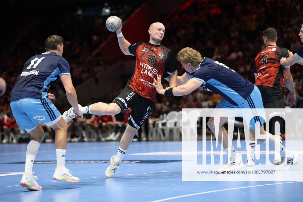 Melf Hagen (20), of MTV Braunschweig, takes off for a jump shot while being held by the arm by an HSV Hamburg player. Nicolaj Jørgensen (11), of HSV Hamburg, can be seen on the left side of the photo. Melf Hagen (20), of MTV Braunschweig, taking a jump shot against HSV Hamburg