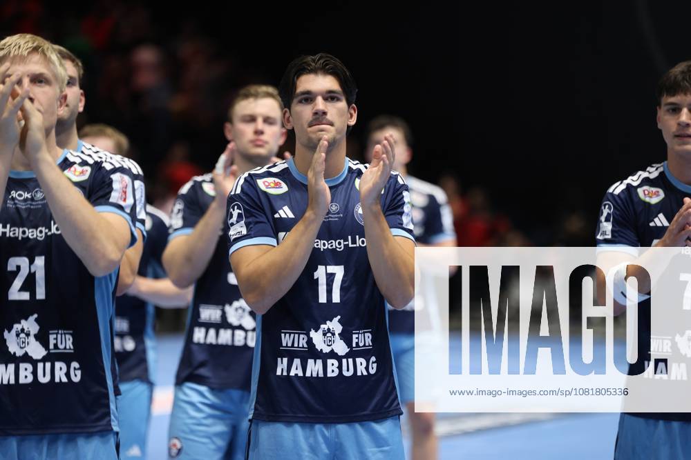 Kaj Geenen (17), HSV Hamburg, joins Frederik Bo Andersen (21), HSV Hamburg, and other teammates in applauding the crowd. The team stands together on the court at the Volkswagen Halle in Braunschweig. Kaj Geenen (17), HSV Hamburg, applauds with his teammates after the game.