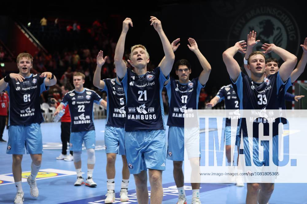 Frederik Bo Andersen (21), of HSV Hamburg, raises his arms in celebration, flanked by Martin Hovde (81), Noah Beyer (22), Kaj Geenen (17), Moritz Sauter (33), and Alem Hadzic (77) —the entire team celebrates together in front of the fans at the Volkswagen Halle in Braunschweig. The HSV Hamburg team runs as a group toward the spectators and thanks them with exuberant cheers. Frederik Bo Andersen (21), of HSV Hamburg, leads the celebration with his teammates