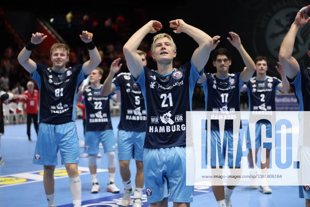 Frederik Bo Andersen 21 (HSV Hamburg) raises his arms in the air and celebrates alongside Martin Hovde 81 (HSV Hamburg), Kaj Geenen 17 (HSV Hamburg), and other teammates in front of the fans at the Volkswagen Halle in Braunschweig. The entire HSV Hamburg team applauds and thanks the crowd after the game. Frederik Bo Andersen, No. 21 of HSV Hamburg, leads the team’s victory celebration