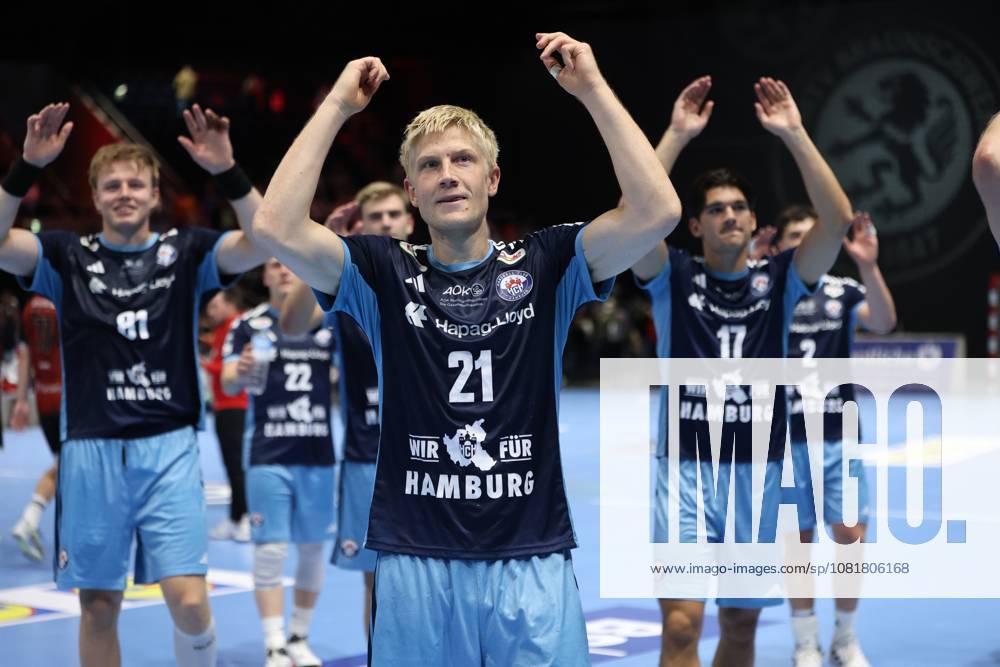 Frederik Bo Andersen 21 of HSV Hamburg raises his arms in triumph and celebrates with his teammates, including Kaj Geenen (17, HSV Hamburg) and Martin Hovde (81, HSV Hamburg), celebrating their victory at the Volkswagen Halle in Braunschweig. The entire HSV Hamburg team applauds the fans together. Frederik Bo Andersen (21, HSV Hamburg) celebrates after the victory.