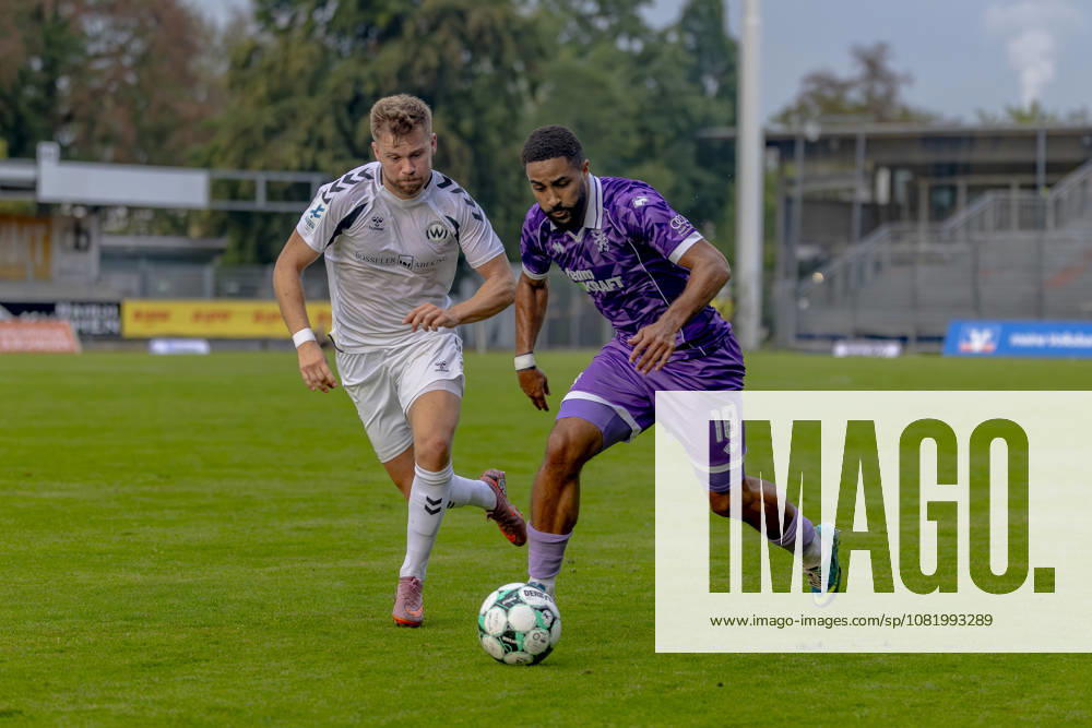 Burghausen, Germany, August 25, 2026, Toto Cup, 2026–2027 Bavarian State Cup, Round of 16: SV Wacker Burghausen vs. FC Ingolstadt 04. Pictured, from left, in a tackle: Alexander Gordok (Burghausen) and Keanan Bennetts (FCI) at the Flatbuy Stadium in Bavaria.