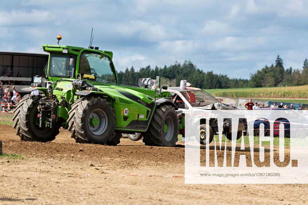 A heavily damaged stock car is recovered from the racetrack using a telescopic loader during the FUN CROSS stock car race near Dietenwengen. The vehicle is no longer drivable after a race and is lifted and removed from the track area. FUN CROSS stock car race in Eberhardzell, Eberhardzell, Dietenwengen
