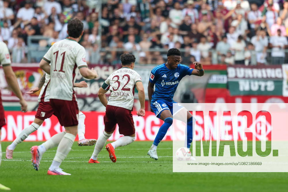 Junior Adamu (FC Schalke 04), 20, with the ball alongside Fabian Rieder (FC Augsburg), 32, GER, FC Augsburg vs. FC Schalke 04, soccer, Bundesliga, Matchday 1, 2026–2027 season, August 30, 2026, DFL and DFB regulations prohibit any use of photographs as image sequences and or quasi-video, GER, FC Augsburg vs. FC Schalke 04, Soccer, Bundesliga, Matchday 1, 2026–2027 Season, August 30, 2026, Augsburg