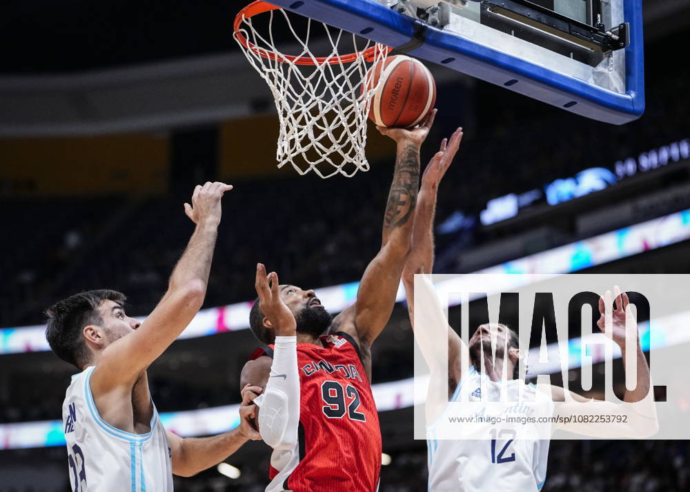 Canada s Khem Birch (92) goes to the net under pressure from Argentina s Gonzalo Bressan (18) and teammate Leandro Bolmaro (12) during their FIBA world cup qualification action in Quebec City, Monday, Aug. 31, 2026. Khem Birch (92) Leandro Bolmaro (12) - ZUMAc35_ 20260831_zaf_c35_080