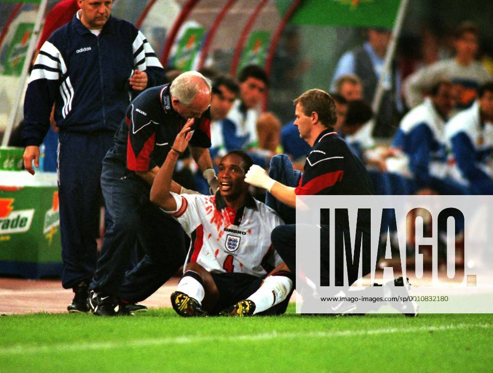 Football : Italy v England World Cup Qualifier in Rome.11 10 1997 Paul Ince (Eng) complains to the referee as he receives attention from Physio, Gary Lewin, for a cut head as he sits on the ground in his blood stained shirt.