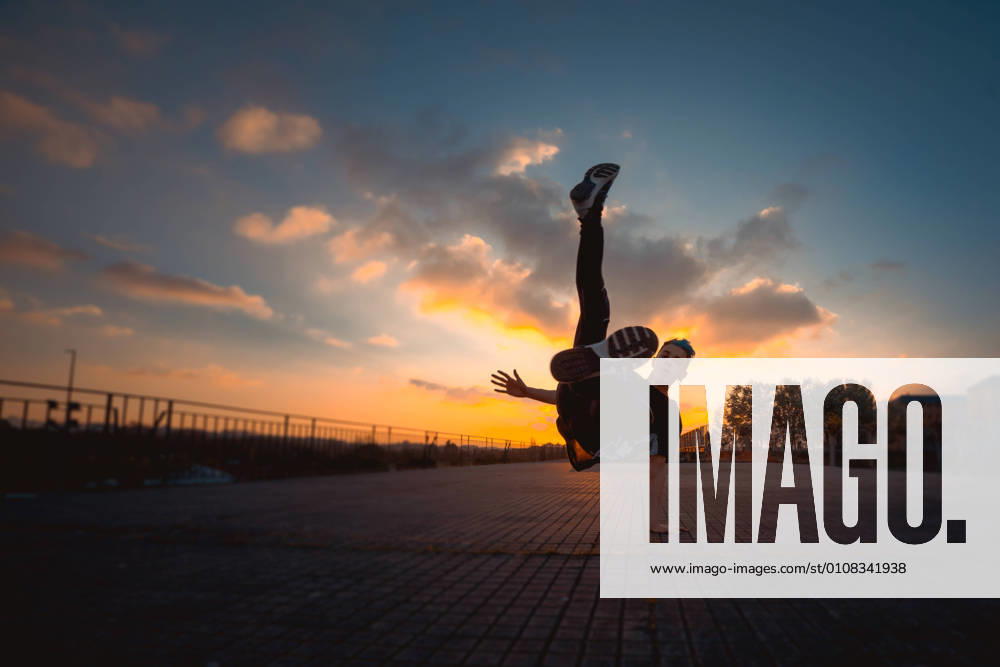 Teenager break dancing in evening park, Model released