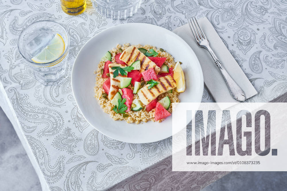 Appetizing Bulgur salad with watermelon and cucumbers in plate served on table for tasty lunch