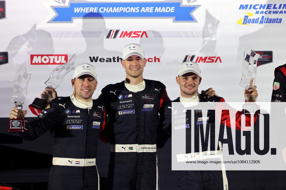 Robin Frjins (NED), Sheldon van der Linde (RSA), Dries Vanthoor (BEL) in the BMW M Hybrid V8 24, finishing second with trophies on the podium; awards ceremony; IMSA racing series; 29th Motul Petit Le Mans race; Road Atlanta, Georgia, USA; October 3, 2026, 10-hour race
