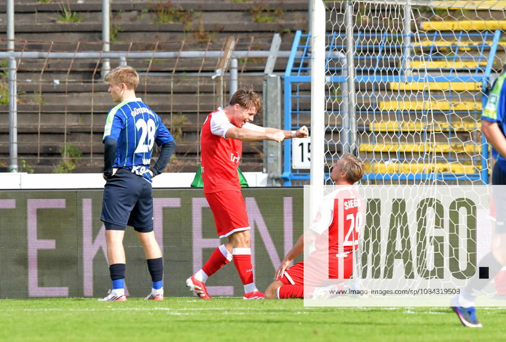 Germany, Soccer, Regionalliga West, 2026–2027 Season, Matchday 12, Ohlendorf Stadium in Heidewald, Gütersloh FC vs. SF Siegen 0–5. Goal celebration: SF Siegen’s Konstantin Gerhardt and goal scorer Elias Paul Huth, both of SF Siegen (from left), celebrate the 0–1 goal, Erik Lanfer of FC Gütersloh looks disappointed; action shot, single frame, horizontal, facial expressions, gestures, celebration, cheering, joy, happiness