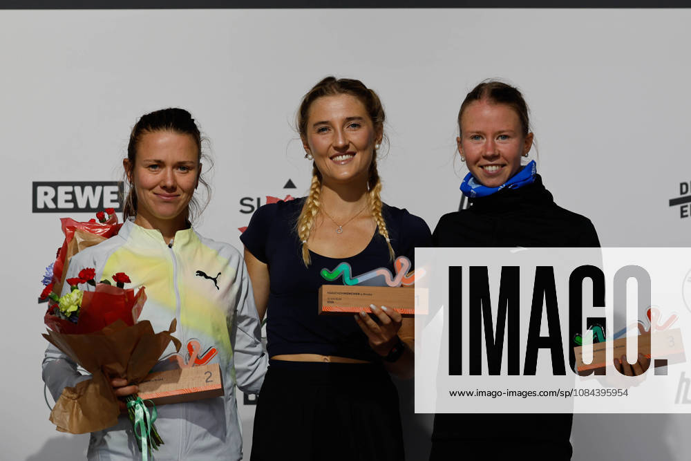2026 Munich Marathon, Munich, October 11, 2026. The top three women, from left to right: 2nd place, Tereza HROCHOVÁ CZE Munich Athletics, winner Lisa REDLINGER AUT TS Lustenau, 3rd place Julie VOET BEL, beaming during the award ceremony after the 10 km race as part of the 2026 Munich Marathon, Munich