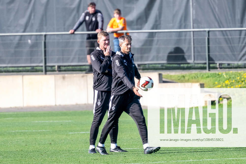 Alexander Blessin of Borussia Mönchengladbach, head coach, kicks the ball toward the sideline at the end of practice, with Markus Gellhaus of Borussia Mönchengladbach, assistant coach, nearby. Public practice: Borussia Mönchengladbach, soccer, Bundesliga, 2026–2027 season, October 14, 2026, public training session for Borussia Mönchengladbach, soccer, Bundesliga, 2026–2027 season, October 14, 2026, Mönchengladbach