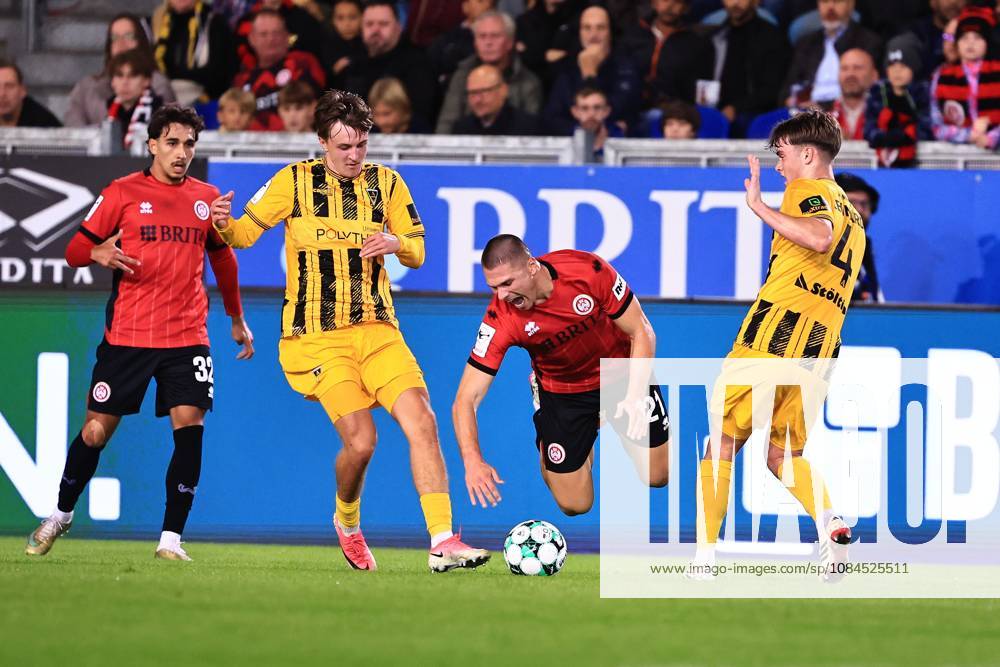 Marcus Mueller of SV Wehen Wiesbaden, 21, goes down in a tackle with Kacper Koscierski of Alemannia Aachen, 29, on the left, and Dylan Leonard of Alemannia Aachen, 04, GER, SV Wehen Wiesbaden vs. Alemannia Aachen, Soccer, 3rd Division, Matchday 9, 2026–2027 season, October 14, 2026 DFB regulations prohibit any use of photographs as image sequences and or quasi-video GER, SV Wehen Wiesbaden vs. Alemannia Aachen, Soccer, 3rd Division, Matchday 9, 2026–2027 Season, October 14, 2026, Wiesbaden