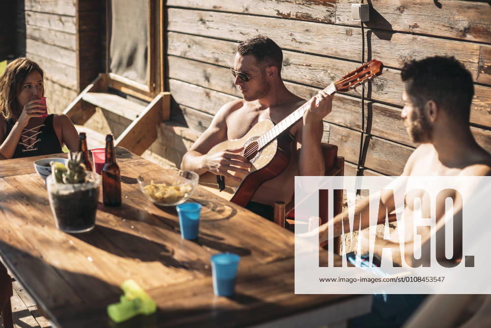 IMAGO Creative: Gesellschaft, Integration Guy playing guitar for his friends, Model released, Property released