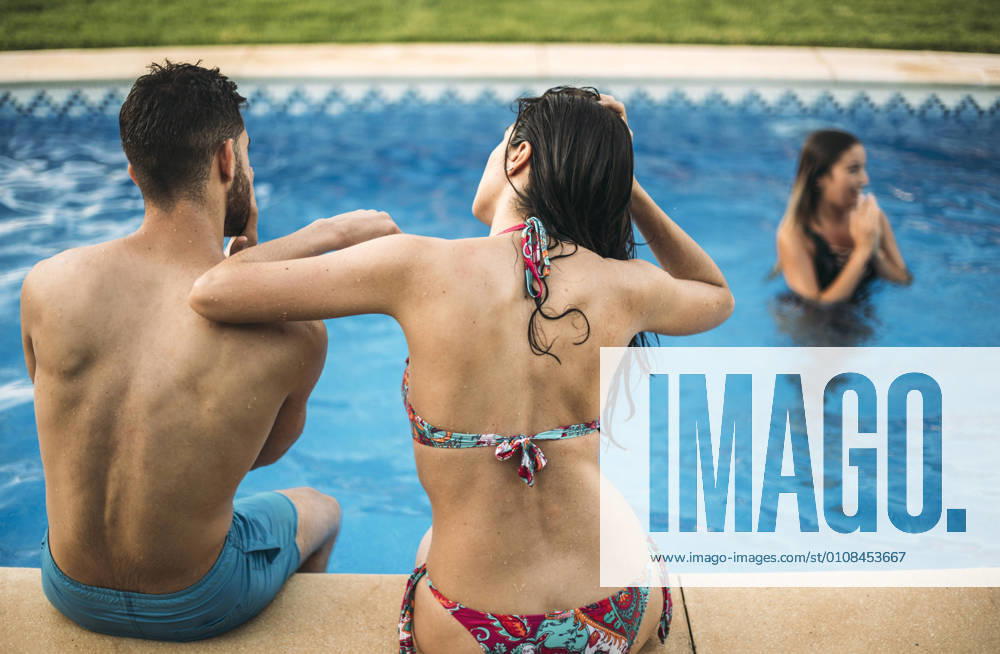 Friends sitting on edge of pool, Model released, Property released