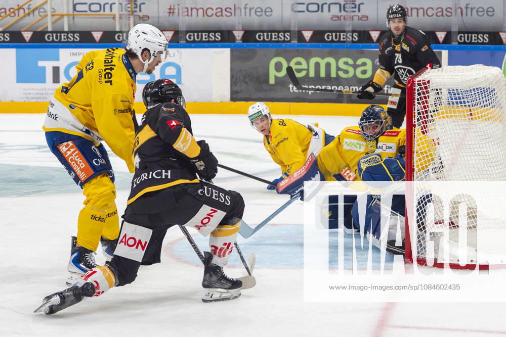 LUGANO, SWITZERLAND OCTOBER 16: Davos R goalkeeper Sandro Aeschlimann makes a save against Lugano s Ramon Tanner (second from left) during the game between HC Lugano and HC Davos at the Corner Arena on October 16, 2026, in Lugano, Switzerland. Lugano, Ticino, Switzerland