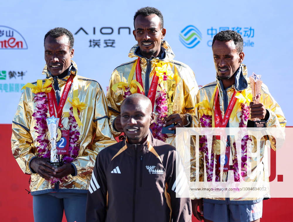 (261018) -- BEIJING, Oct. 18, 2026 -- (top L to R)Second-placed Muktar Edris of Ethiopia, first-placed Tamirat Tola of Ethiopia and third-placed Adane Kebede Gebre of Ethiopia pose with guest Sabastian Sawe of Kenya during the awarding ceremony for the men s marathon event at the 2026 Beijing Marathon & National Marathon Championships in Beijing, capital of China, Oct. 18, 2026. ) (SP)CHINA-BEIJING-2026 BEIJING MARATHON(CN) LuoxYuan