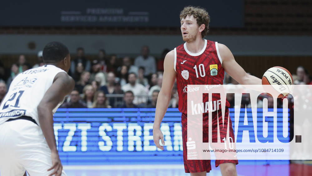 Pictured from left: Kris Clyburn (SYNTAINICS MBC), 21, against Calvin Wishart (Würzburg Baskets), 10, with the ball, August 18, 2026, Fitness First Würzburg Baskets vs. SYNTAINICS MBC, Netto BBL Cup, Round of 16, Germany, 97072, tectake Arena Würzburg,