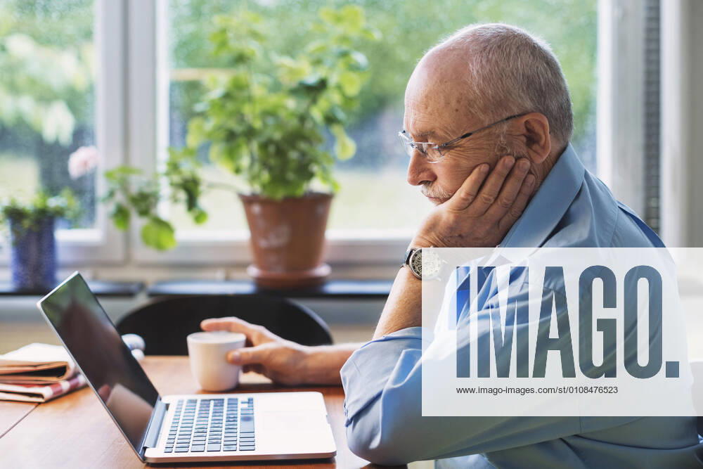 Senior man using laptop at home , model released, property released