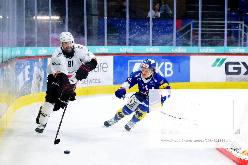 Swiss Ice hockey, Eishockey - EHC Kloten vs Lausanne Hockey - Lausanne Defender Fabian Heldner (91) defends the puck by EHC Kloten Forward Mischa Ramel (14)