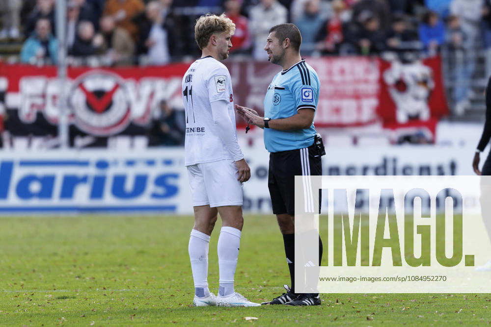 Referee Niclas Rose (Satow) discusses with Moritz Kaube (SC Verl, 11) during the 3rd division match on gameday 11 between Viktoria Koeln vs. SC verl at the Sportpark Hoehenberg on October 24, 2026 in Koeln, Germany. DFL REGULATIONS PROHIBIT ANY USE OF PHOTOGRAPHS AS IMAGE SEQUENCES AND OR QUASI-VIDEO. Nordrhein-Westfalen Germany