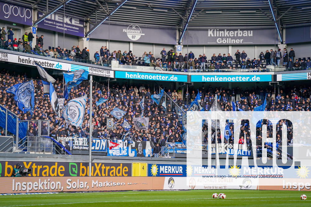 Germany Soccer Bundesliga 2026–2027, Matchday 7: SC Paderborn vs. Hamburger SV at Home Deluxe Arena in Paderborn. Home and away fans of Hamburger SV (HSV) in the visitors’ section of the Home Deluxe Arena in Paderborn. A densely packed visitors’ section with numerous blue, white, and black flags, fan banners, banners, and scarves. Fan culture, ultras, organized fan scene, away game, soccer, Bundesliga, spectators, atmosphere, support, fan section, stands, wide shot, stadium, sports venue, security fence, advertising, sponsors, advertising banners, Merkur, buXtrade, HENKENOTTER