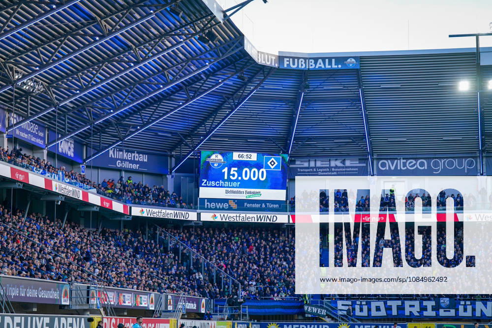 Germany Soccer Bundesliga 2026–2027, Matchday 7: SC Paderborn vs. Hamburger SV at Home Deluxe Arena, Paderborn. Scoreboard at Home Deluxe Arena in Paderborn showing an attendance of 15,000 for the Bundesliga match between SC Paderborn 07 and Hamburger SV (HSV). Sold-out stadium, stadium display, attendance record, attendance, fans, packed stands, fan section, fan block, Ultras, flags, banners, PATRICUM, soccer, Bundesliga, sports venue, interior view, wide shot, stadium roof, floodlights, advertising, sponsors, WestfalenWIND, hewe, avitea group, Klinkerbau Göllner